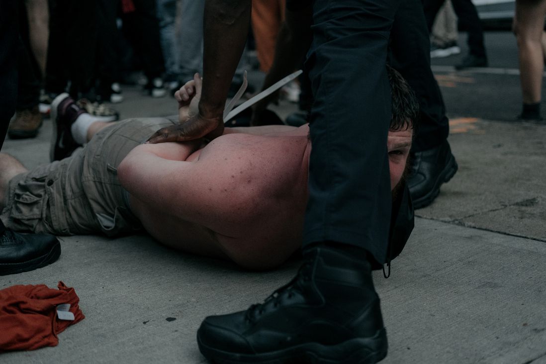 A protester is held on the ground by police.